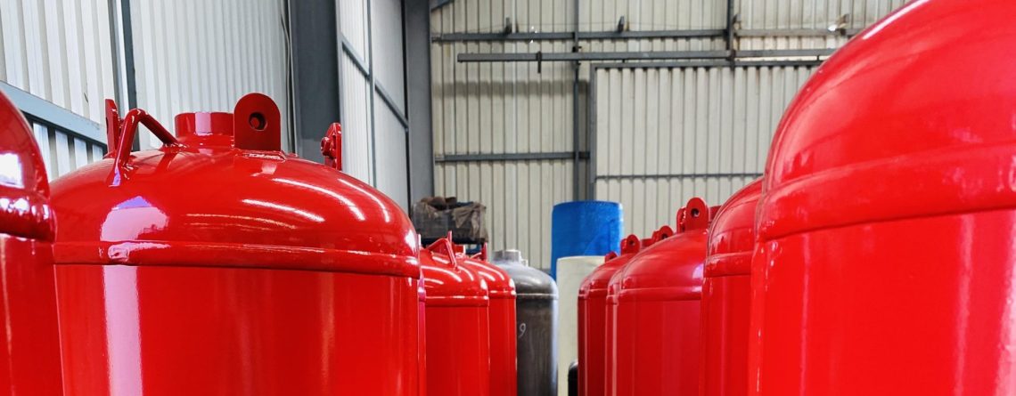 Production line of red TPED-certified clean agent fire suppression cylinders ready for shipment