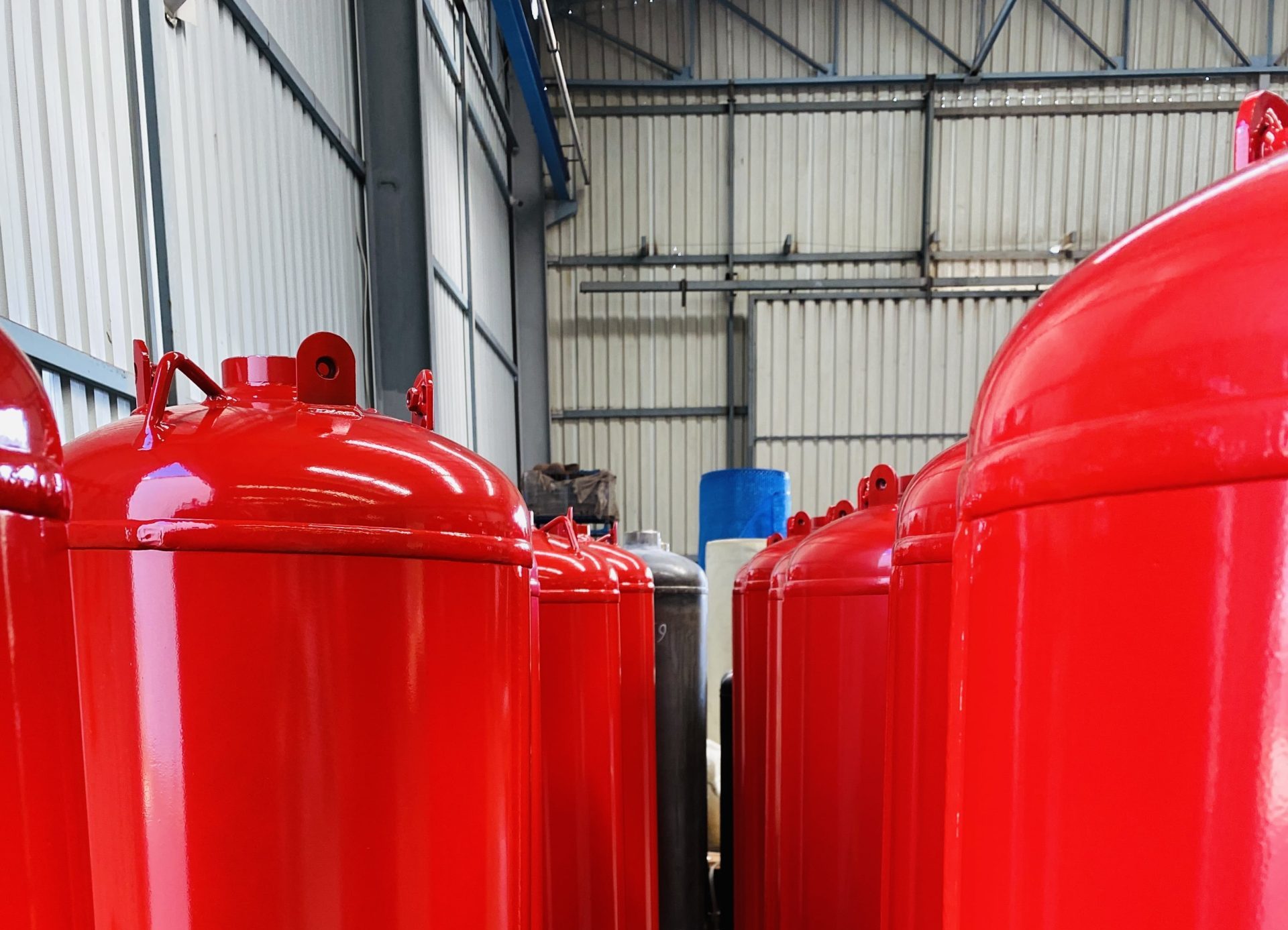 Production line of red TPED-certified clean agent fire suppression cylinders ready for shipment