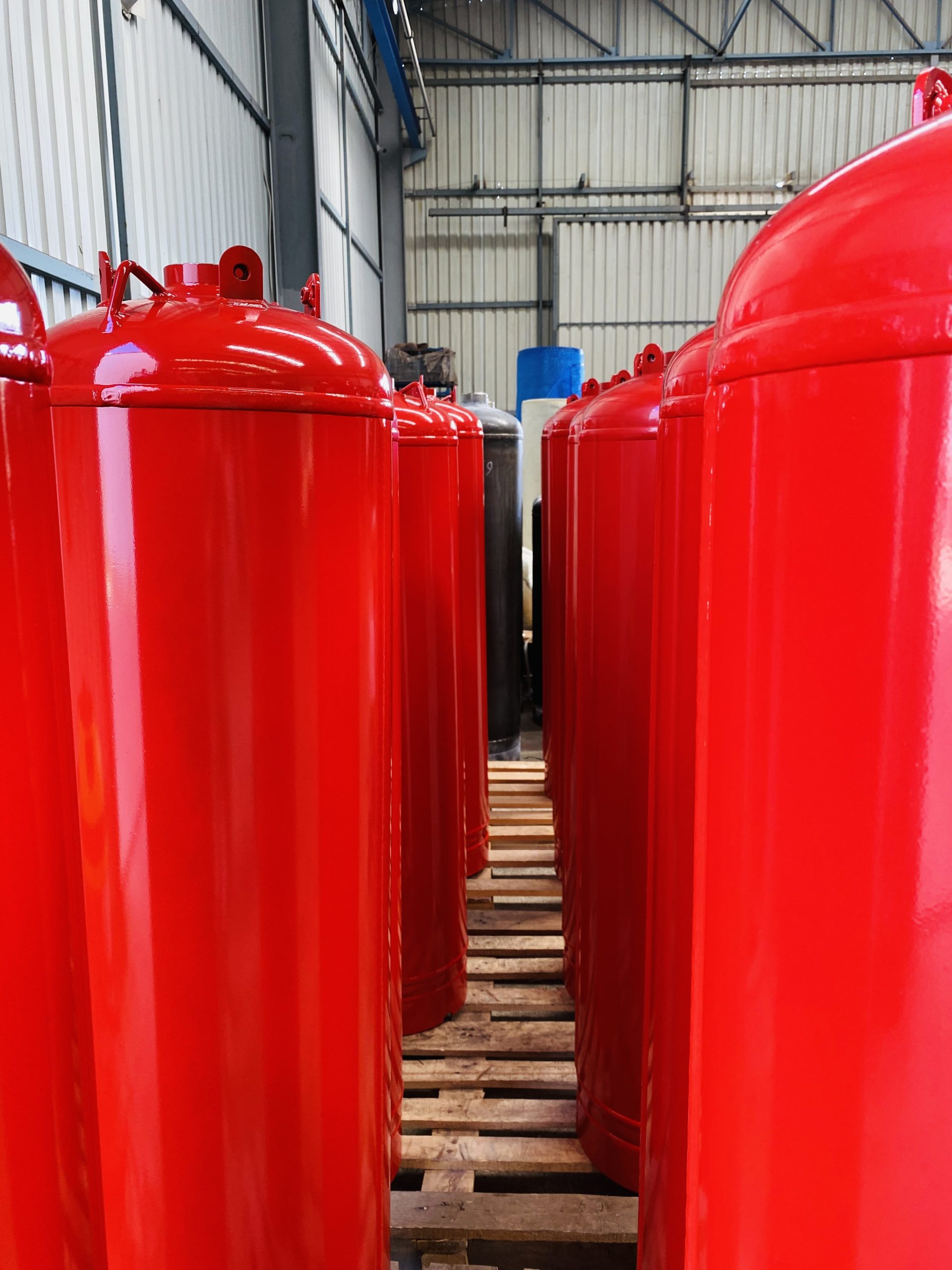 Production line of red TPED-certified clean agent fire suppression cylinders ready for shipment