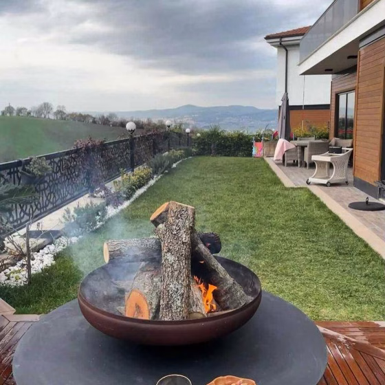 Fumolio Fuji Fire Pit with wood storage in outdoor area