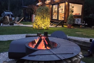 Eltegon Maria fire pit burning outside a tiny house, offering warmth and style for compact outdoor spaces