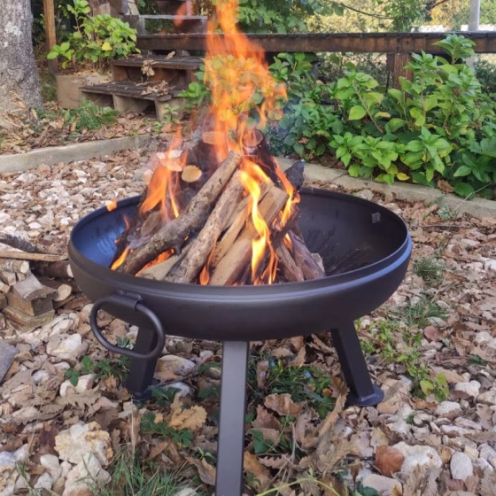 Fumolio Etna Fire Pit – premium handmade steel fire pit with tripod legs burning wood in a natural outdoor setting